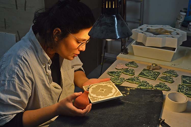 Painting a tile at the ceramics workshop
